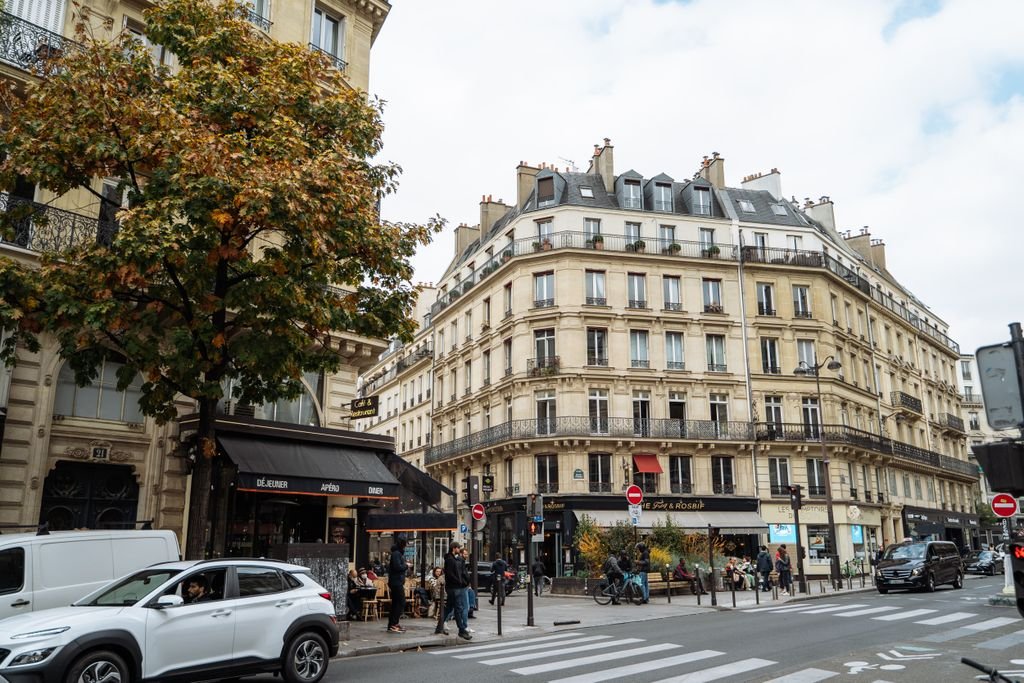 A picturesque view of a Paris street showcasing classic architecture and autumn vibes.