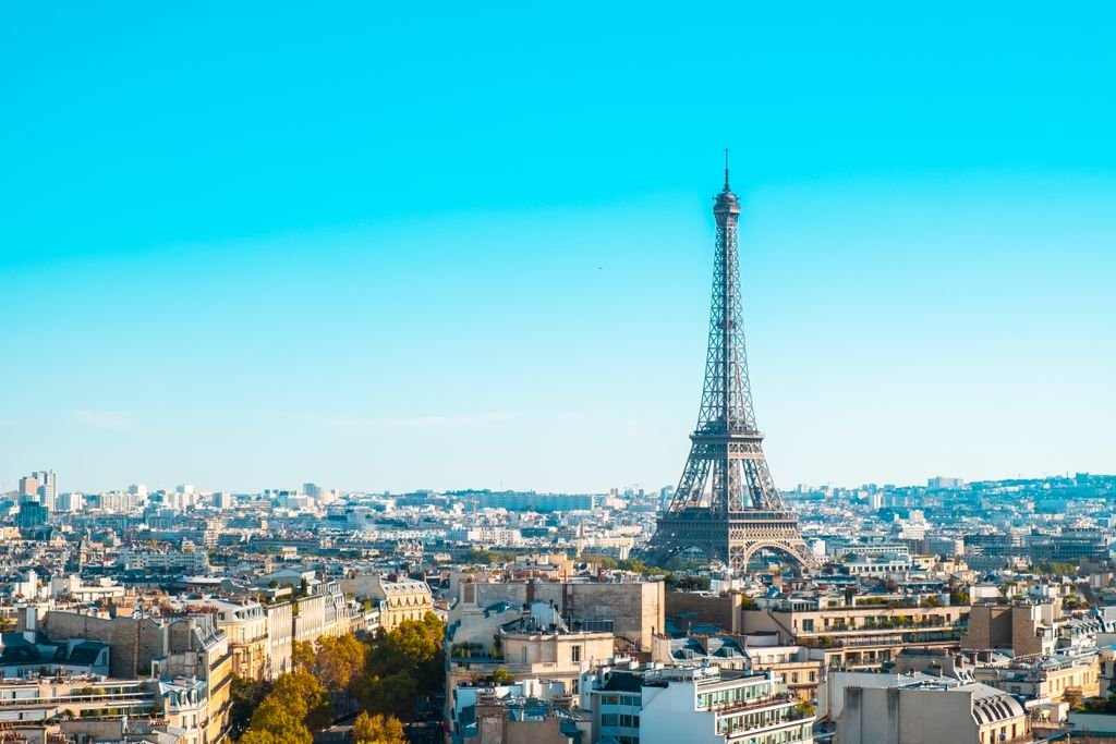 Eiffel Tower overlooking the cityscape of Paris under clear blue skies.