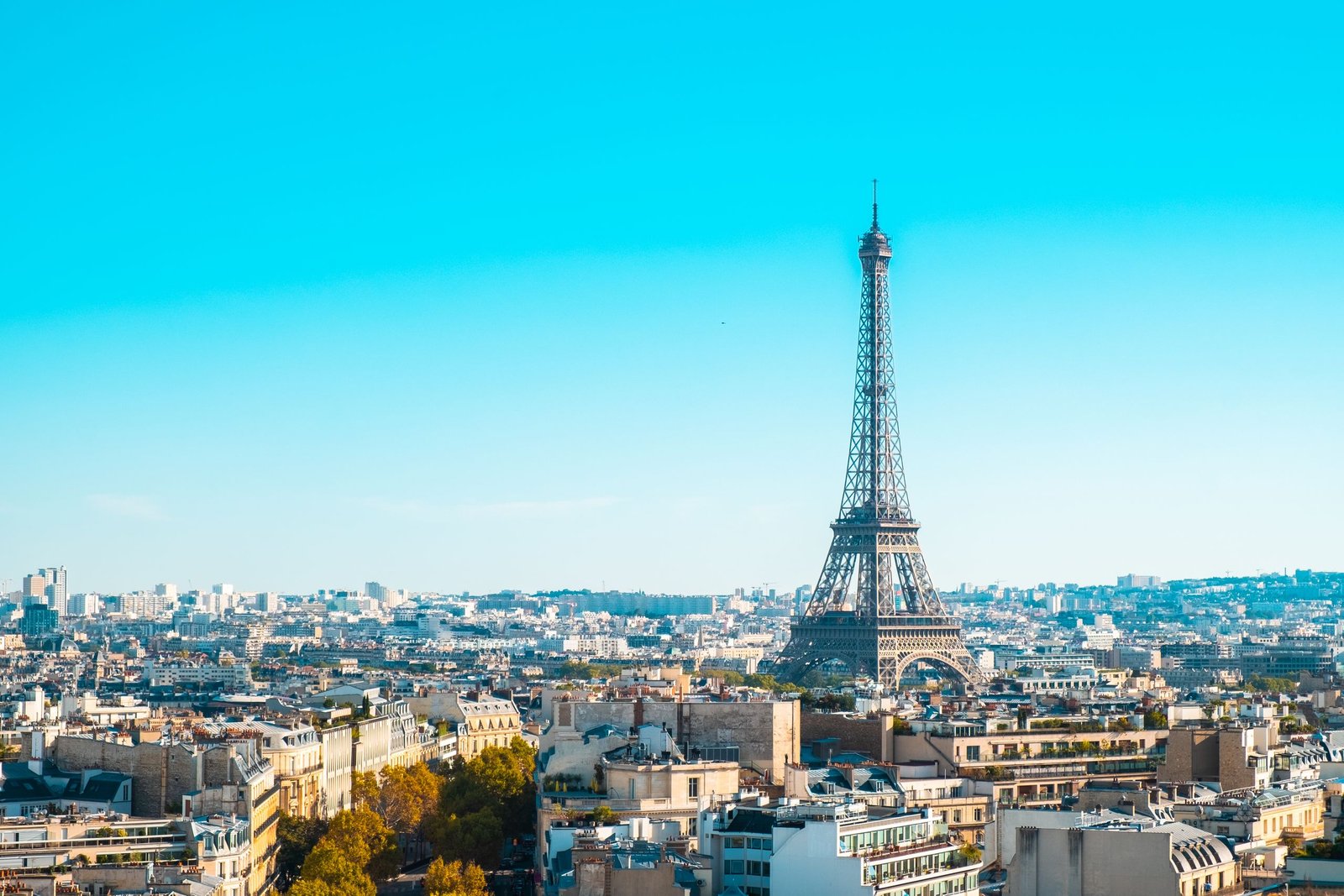 Eiffel Tower overlooking the cityscape of Paris under clear blue skies.